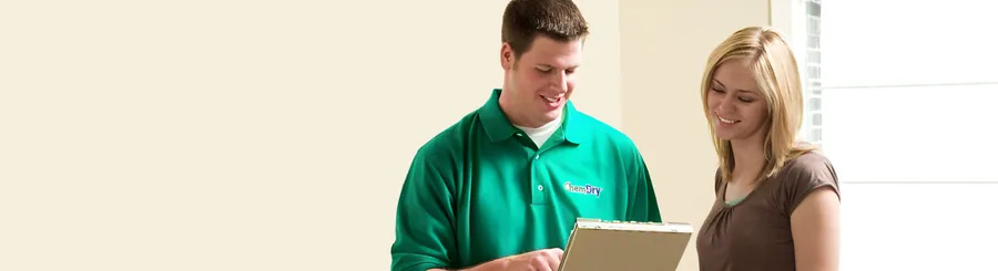 A Chem-Dry technician talking a client through a drapery clean