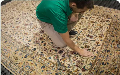 A Chem-Dry technician working a hand-knotted rug by hand