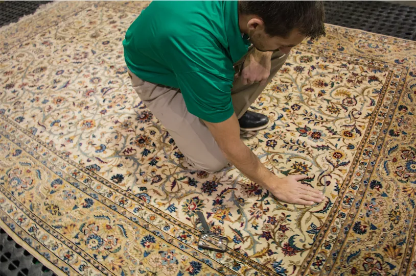 A Chem-Dry technician inspecting a hand-knotted area rug