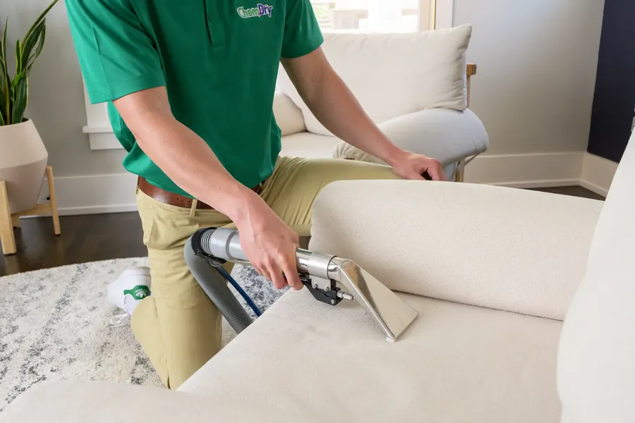 A Chem-Dry technician deep cleaning an upholstered lounge suite